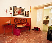 Hallway with thonet bench and iron table against red wall