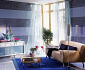 Wohnzimmer: blauer Teppich, transparente Vorhänge, Marmortapete