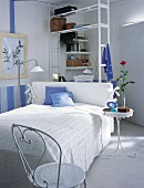 Weißes Schlafzimmer mit Metallmöbeln und blauen Farbtupfern