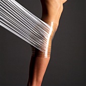 Close-up of nude woman wrapped in foil around hips for aroma therapy