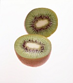 Two halves of kiwi fruit on white background