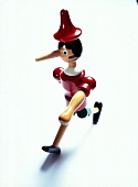 Close-up of wooden figure of Pinocchio against white background
