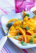 Saffron risotto garnished with coriander and carrots on plate