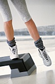 Close-up of woman's legs wearing sports shoes, exercising on stepper