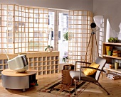 Living room with wood lattice panel in front of windows and TV on table