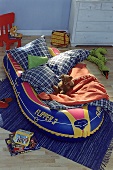 Schlauchboot als Kindergästebett mit Kissen und Decken, Teddy
