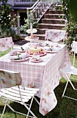 Kaffeetafel im Garten: weiß-rosa karierte Decke mit Rosenbordüre.