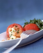 Close-up tomatoes with stuffing of salmon, cheese and herbs on plate