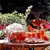 Melonen-Erdbeer-Bowle in Glasschüssel und Gläsern