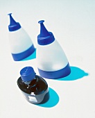 Hair dye and applicator bottle against white background