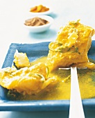 Close-up of spiced halibut in yogurt sauce on blue plate