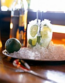 Glass of caipirinha cocktail with lemon slices and ice on plate