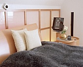 Japanische Wand hinter einem Bett aus hellem Buchenholz