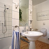 rundes weißes Waschbecken mit schlichten Armaturen, Holzboden