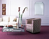 Wohnraum mit modernem Glastisch, weißer Couch, rotem Teppich
