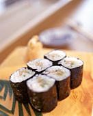 Sushi: Negi-Shake Maki, 6 Stücke liegen auf einem Holzbrett