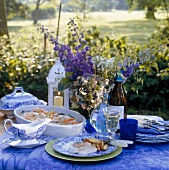 Blue buffet table with crockery, lavender flower, food and champagne bottle