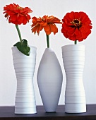 Weißes Vasentrio aus handgeformter Keramik,drei einzelne rote Blüten.