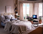 Schlafzimmer mit Doppelbett, in hellen Pastellfarben, Fernsehtisch