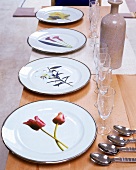 weiße Teller mit aufgedruckten Blumenmotiven auf einem Tisch
