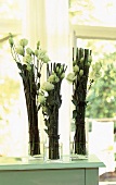 Drei Sträuße aus grünem Bambus und Blütenzweigen