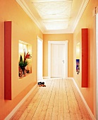 Flur mit Holzfußboden, Wände orange, warme Beleuchtung, modern