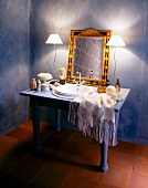 Vanity with mirror next to lamp and cosmetic products