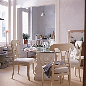 Eßplatz: Tisch mit Glasplatte, weiße Holzstühle, im Hintergrund Küche