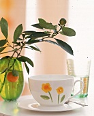 Kaffeetasse in sommerlichem Design mit kleinen Blumen, grüne Vase
