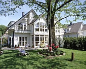 Weisses Doppelhaus mit versetzten Giebel, Terrasse und Garten