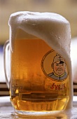 Bierglas mit dem Soldaten Svejk und überlaufendem tchechischem Bier
