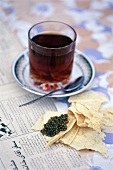 Ein Glas Tee zu Osietra-Kaviar auf dünnem Fladenbrot, Unschärfe