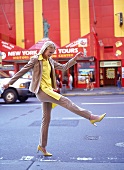 Frau hüpft fröhlich auf einer Straße in New York