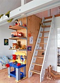 Teil von einem Kinderzimmer mit einer Leiter zum Spielboden