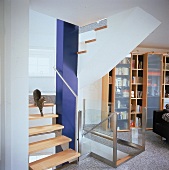 Ahorntreppe mit einem Glas-Geländer, blauer Stützpfeiler in der Mitte