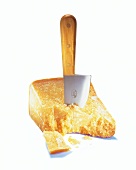 Parmesan cheese with knife on white background