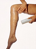 Limphdrainage: Frau wickelt ihr Bein mit Spezialfolie ein