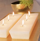 Zwei weiße Kerzen in Kuchenform mit drei Dochten