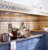 View of tiled kitchen wall with basin and stainless steel appliances