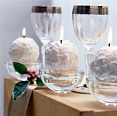 Lit snowball candles in glass cup