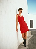 Frau trägt Kleid in rot Volants am Saum, Stiefel, Halsband