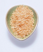 Parboiled Reis; rohe Körner in einer hellgrünen Keramikschale