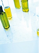 5 helle Glasflaschen, mit Olivenöl gefüllt,angeschnitten,Unschärfe