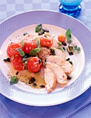 Chicken breast fillet with braised cherry tomatoes and fresh basil on plate