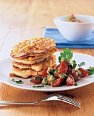 Aufgetürmte Maispuffer mit einer Tomaten-Koriander-Salsa angerichtet