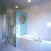 Turquoise mosaic partition between bath tub and shower