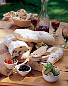 Italienisches Brot,davor Schälchen mit Oliven,Paprika u. Artischocken