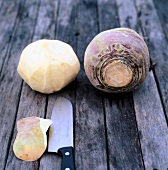 Turnips with and without skin on wooden table