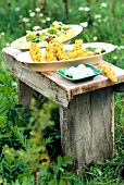 Croutons with lettuce on vesper plate and bowl of herb cheese on wooden table