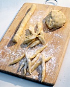 Close-up of potato noodles being formed on wooden board